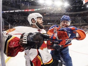 Calgary Flames' Deryk Engelland (29) is checked by Edmonton Oilers' Matt Hendricks (23) during second period NHL action in Edmonton, Alta., on Saturday January 14, 2017.
