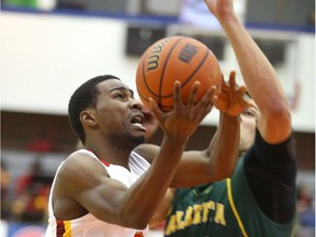 U of C Dinos' David Kapinga goes for a layup against Golden Bears Brody Clarke during the 2016 Canada West men's basketball playoffs in Calgary. The two sides are currently in a home-and-away series to help decide supremacy in the province this season. (Jim Wells)