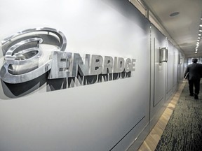 An Enbridge employee walks past signage at the company's head office in Calgary in this file photo.