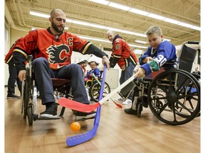 Calgary Flames captain Mark Giordano stickhandles against Carson of the Townsend Tigers during their annual wheelchair floor hockey game at the Alberta Children's Hospital in Calgary on Tuesday, Jan. 31, 2017. The Tigers, made up of kids who attend Dr. Gordon Townsend school at the hospital, beat the Flames 15-0 for their 36th consecutive win in a row. (Lyle Aspinall)