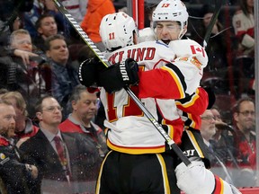 Calgary's Johnny Gaudreau (right) jumps in the arms of his elated teammate Mikael Backlund after scoring the overtime goal to win 3-2 with 30 seconds left against the Ottawa Senators at Canadian Tire Centre Thursday (Jan. 26, 2017).  Julie Oliver/Postmedia