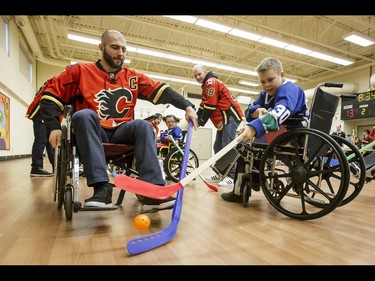 Calgary Flames captain Mark Giordano goes for the ball against Carson of the Townsend Tigers during an annual wheelchair floor hockey game between the Townsend Tigers and the Flames at the Alberta Children's Hospital in Calgary, Alta., on Tuesday, Jan. 31, 2017. The Townsend Tigers, made up of kids who attend Dr. Gordon Townsend School at the hospital, beat the Flames for the 36th year in a row, this year by a 15-0 score. Lyle Aspinall/Postmedia Network