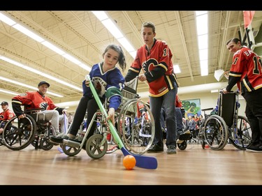 Mataya of the Townsend Tigers is helped by Matthew Tkachuk of the Calgary Flames during an annual wheelchair floor hockey game between the Townsend Tigers and the Flames at the Alberta Children's Hospital in Calgary, Alta., on Tuesday, Jan. 31, 2017. The Townsend Tigers, made up of kids who attend Dr. Gordon Townsend School at the hospital, beat the Flames for the 36th year in a row, this year by a 15-0 score. Lyle Aspinall/Postmedia Network