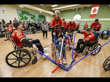 Dougie Hamilton of the Calgary Flames pushes Keshini of the Townsend Tigers between Jyrki Jokipakka and Brett Kulak during an annual wheelchair floor hockey game between the Townsend Tigers and the Flames at the Alberta Children's Hospital in Calgary, Alta., on Tuesday, Jan. 31, 2017. The Townsend Tigers, made up of kids who attend Dr. Gordon Townsend School at the hospital, beat the Flames for the 36th year in a row, this year by a 15-0 score. Lyle Aspinall/Postmedia Network