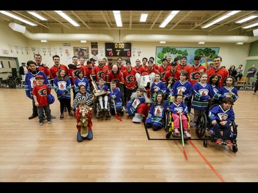 The Calgary Flames pose for a group photo with the Townsend Tigers after an annual wheelchair floor hockey game between the Townsend Tigers and the Flames at the Alberta Children's Hospital in Calgary, Alta., on Tuesday, Jan. 31, 2017. The Townsend Tigers, made up of kids who attend Dr. Gordon Townsend School at the hospital, beat the Flames for the 36th year in a row, this year by a 15-0 score. Lyle Aspinall/Postmedia Network