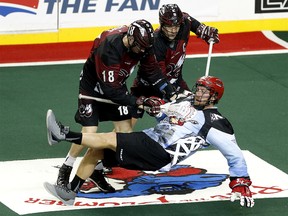 Calgary Roughnecks Tyler Burton, right, collides with Colorado Mammoth players Robert Hope, left and Brent Coates at the Scotiabank Saddledome in Calgary on Saturday January 28, 2017.
