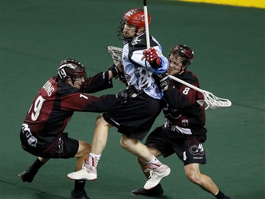 Calgary Roughnecks Curtis Dickson, middle, collides with Colorado Mammoth players Cameron Holding, left and Greg Downing at the Scotiabank Saddledome in Calgary, Alta. on Saturday January 28, 2017. Leah Hennel/Postmedia