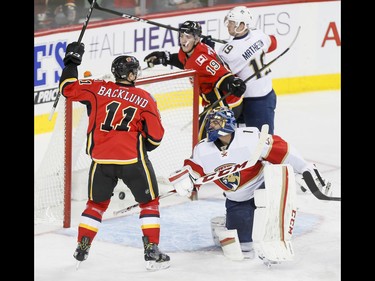 Mikael Backlund and Matthew Tkachuk of the Calgary Flames celebrate a Backlund goal near Michael Matheson of the Florida Panthers and goalie Roberto Luongo during NHL action in Calgary, Alta., on Tuesday, Jan. 17, 2017. Lyle Aspinall/Postmedia Network