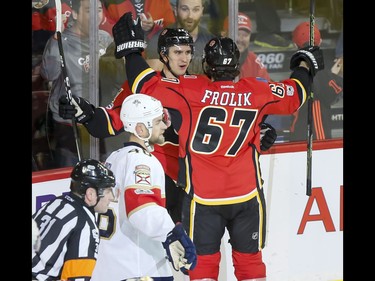 Mikael Backlund and Michael Frolik of the Calgary Flames celebrate Backlund's second of two second-period goals near Jakub Kindl of the Florida Panthers during NHL action in Calgary, Alta., on Tuesday, Jan. 17, 2017. Lyle Aspinall/Postmedia Network