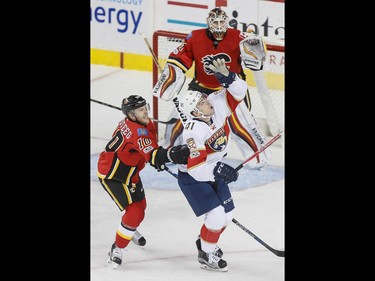 Greg McKegg of the Florida Panthers catches a puck near Kris Versteeg of the Calgary Flames and Calgary Flames goalie Chad Johnson during NHL action in Calgary, Alta., on Tuesday, Jan. 17, 2017. Lyle Aspinall/Postmedia Network