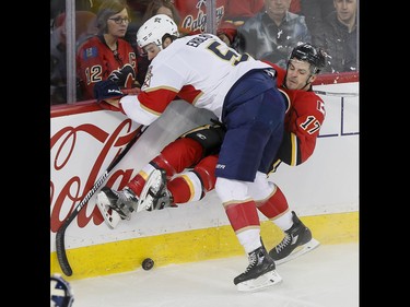 Lance Bouma of the Calgary Flames is hit by Aaron Ekblad of the Florida Panthers during NHL action in Calgary, Alta., on Tuesday, Jan. 17, 2017. Lyle Aspinall/Postmedia Network