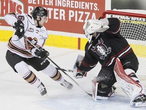 Jake Kryski of the Calgary Hitmen scores on Red Deer Rebels goalie Lasse Petersen during WHL action in Calgary, Alta., on Wednesday, Jan. 18, 2017.