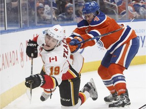 Calgary Flames' Matthew Tkachuk (19) is checked by Edmonton Oilers' Kris Russell (4) during third period NHL action in Edmonton, Alta., on Saturday January 14, 2017.