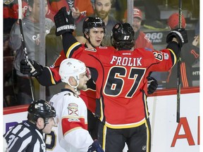 Mikael Backlund and Michael Frolik of the Calgary Flames celebrate Backlund's second of two second-period goals near Jakub Kindl of the Florida Panthers during NHL action in Calgary, Alta., on Tuesday, Jan. 17, 2017. Lyle Aspinall/Postmedia Network