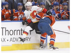 Calgary Flames' Mikael Backlund (11) is checked by Edmonton Oilers' Oscar Klefbom (77) during first period NHL action in Edmonton, Alta., on Saturday January 14, 2017.