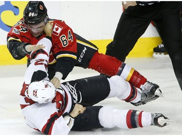 New Jersey Devils Kyle Quincey, bottom, and Calgary Flames Garnet Hathaway fight in NHL hockey action at the Scotiabank Saddledome in Calgary, Alta. on Friday January 13, 2017. Leah Hennel/Postmedia