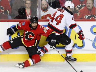 New Jersey Devils Miles Wood, right, collides with Calgary Flames Deryk Engelland in NHL hockey action at the Scotiabank Saddledome in Calgary, Alta. on Friday January 13, 2017.