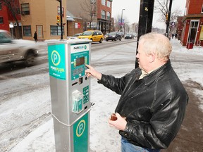 Mark Donnelly plugs money into a ParkPlus kiosk in Kensington.