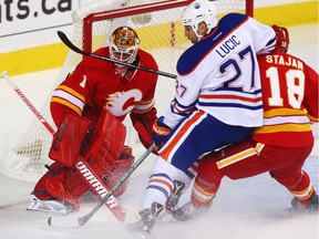 Calgary Flames Brian Elliott makes a save on Milan Lucic  of the Edmonton Oilers during NHL hockey in Calgary, Alta., on Friday, October 14, 2016. The two teams face each other again on Saturday in Edmonton.