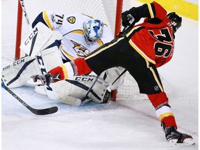 The Calgary Flames Troy Brouwer tries to get the puck past Nashville Predators goaltender Juuse Saros during NHL action at the Scotiabank Saddledome in Calgary on Thursday January 19, 2017.