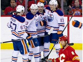 The Edmonton Oilers celebrate their 6th goal while dejected Calgary Flames defenceman Dennis Wideman kneels on the ice during second period NHL action at the Scotiabank Saddledome in Calgary on Saturday January 21, 2017.