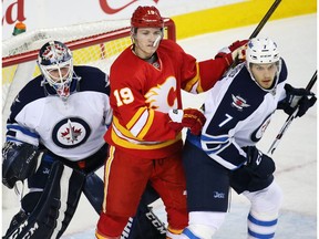 Calgary Flames forward Matthew Tkachuk fights for position between Winnipeg Jets goaltender Michael Hutchinson and defencemen Ben Chiarot at the Scotiabank Saddledome on Dec. 10, 2016. (Gavin Young)