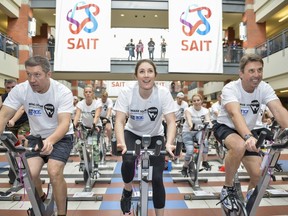 Sheldon Kennedy (left), Anastasia Bucsis (Team Canada, Speedskating; RBC Olympian), Mark Kosak (Alberta Colleges Athletic Conference CEO) join a 100-person spin class to kick off the SAIT Trojans' series of events for Make Some Noise for Mental Health.  Andrew Crossett photo, courtesy SAIT.