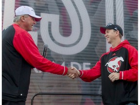 Team president and general manager John Hufnagel (L) shakes hands with new head coach Dave Dickenson during the Calgary Stampeders Fanfest at McMahon Stadium in Calgary, Alta., on Saturday, May 14, 2016. Hufnagel extended the contracts of the coaching staff for the upcoming season.