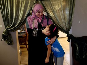 Syrian refugees Seham Talab with one of her four children Najaf Al Masalmeh at their home in Calgary, Alta., on Saturday January 28, 2017, is worried for their family member in the United states after president Trump issued a travel ban on people from certain countries. Leah Hennel/Postmedia