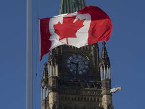 The flag flies at half-mast near the Peace Tower in Ottawa after Sunday's shootings at a Quebec City mosque.