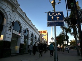 A sign directs pedestrians to the U.S. border crossing in Tijuana, Baja California.  U.S. President Donald Trump announced a proposal to impose a 20 per cent tax on all imported goods from Mexico to pay for the border wall between the United States and Mexico. Mexican President Enrique Pea Nieto canceled a planned meeting with President Trump over who would pay for Trump's campaign promise to build a border wall.