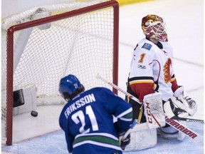Vancouver Canucks left wing Loui Eriksson (21) looks on as a shot from Vancouver Canucks centre Markus Granlund  goes past Calgary Flames goalie Brian Elliott during third period NHL action in Vancouver, B.C. Friday, Jan. 6, 2017.
