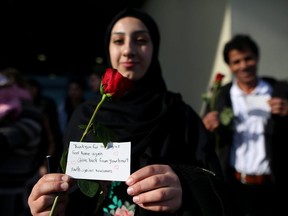 Syrian newcomer, Rama Kanaan, hands out roses to shoppers at Chinook Mall in Calgary, Alta., on Saturday February, 11 2017, to show their appreciation to Canadians. Leah Hennel/Postmedia