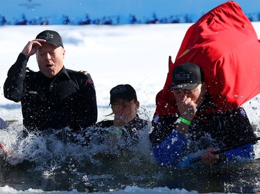 Members of team Tsuu T'ina Police Blue Bloods take an icy dip during the Polar Plunge Calgary on Saturday February 25, 2017, in support of Special Olympics. Leah Hennel/Postmedia