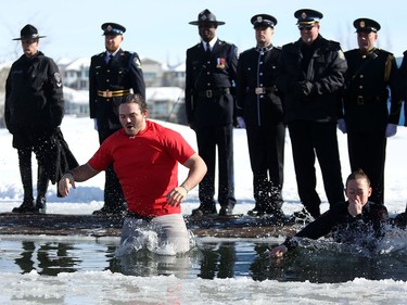 Calgary Stampeders Alex Singleton, left and Calgary police officer Kylie Stone take an icy dip during the Polar Plunge Calgary on Saturday February 25, 2017, in support of Special Olympics. Leah Hennel/Postmedia
