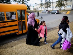 Syrian refugee Fatima al-Rajab greets her children off the school bus after their first week at a new school in Calgary, Alta., on Monday March 14, 2016. Leah Hennel/Postmedia