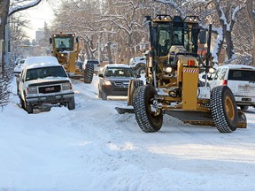 City of Calgary graders make their way around cars parked in the snow ban area on 12th Avenue N.W. on Tuesday afternoon February 7, 2017.
