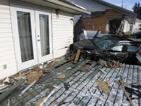 An elderly couple were taken to hospital with undisclosed injuries after their car lost control and slammed into a garage and a home in central Alberta. Police say the Jeep Cherokee, seen here in a police handout image, hit a light standard, then drove the length of a wooden fence, destroying it, and continued on through a detached garage in the town of Olds on Friday morning. THE CANADIAN PRESS/HO-RCMP, *MANDATORY CREDIT*