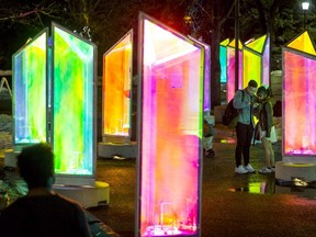 A couple checks their camera inside the Prismatica art installation at Olympic Plaza in Calgary, Alta., on Thursday, Feb. 16, 2017. The temporary display of about two dozen two-metre-high rainbow towers is a precursor to the inaugural GLOW Winter Light Festival happening over the Family Day weekend. Lyle Aspinall/Postmedia Network
