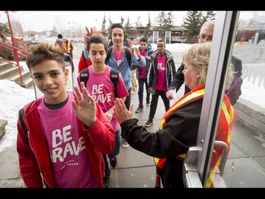 Lisa Teslak high-fives students entering the first-ever BE BRAVE Anti-Bullying Game, a regular-season WHL tilt between the Calgary Hitmen and Brandon Wheat Kings, in Calgary, Alta., on Wednesday, Feb. 22, 2017. More than 8,000 students from Calgary and area were bussed to the morning game as part of Pink Shirt Day, enjoying concourse activities and special entertainment in addition to the regular-season game. Lyle Aspinall/Postmedia Network