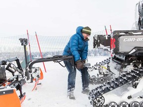 Kevin McLean, president of the Foothills Nordic Ski Club, attaching the groomer to the tow.