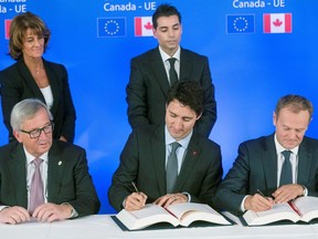 (From L) President of the European Commission Jean-Claude Juncker looks on as Canada's Prime Minister Justin Trudeau (C) and European Council President Donald Tusk sign the Comprehensive Economic and Trade Agreement (CETA), at the European Council in Brussels, on October 30, 2016. Canadian Prime Minister Justin Trudeau and European Union leaders on October 30, 2016 finally signed a landmark trade deal seven years in the making, after it was nearly being torpedoed by a small region of Belgium. CETA removes 99 percent of customs duties between the two sides, linking the single EU market with the world's 10th largest economy. / AFP PHOTO / POOL / Thierry MONASSETHIERRY MONASSE/AFP/Getty Images

1107 ed crook