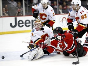 A shot by New Jersey Devils right wing Kyle Palmieri misses the net behind Calgary Flames goalie Brian Elliott Friday, Feb. 3, 2017, in Newark, N.J. (Julio Cortez/AP Photo)