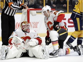 Calgary Flames goalie Brian Elliott and defenceman Michael Stone get up after stopping the puck against the Nashville Predators on Feb. 21, 2017, in Nashville, TN. (AP Photo)