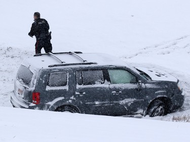 Emergency workers check an SUV that spun out on Deerfoot Trail at Southland Drive on Sunday February 5, 2017. At least 10 cars were involved in several different accidents at the same location.