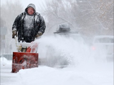 Gerald Elliott acts as a snow angel in the community of Maryland Heights as he clears sidewalks along a block on Sunday February 5, 2017. Snow is forecast continue through Monday and caused collisions across the city.