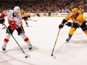 Matt Irwin #52 of the Nashville Predators chases Johnny Gaudreau #13 of the Calgary Flames during the second period at Bridgestone Arena on February 21, 2017 in Nashville, Tennessee.