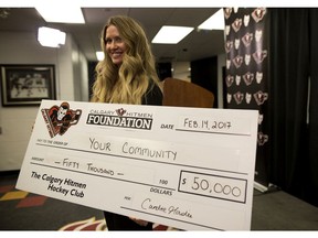 Candice Goudie, Executive Director, Charitable Foundations and Community Investment, holds a cheque for Calgary Hitmen Foundation Community Restoration Program at the Scotiabank Saddledome in Calgary, Alta., on Tuesday February 14, 2017.