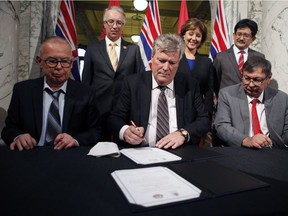Chief Councillor Harold Leighton (front row, left to right), Minister Rich Coleman and Mayor John Helin, and back row, left to right, Minister John Rustad, Premier Christy Clark, and Pacific NorthWest LNG chief project officer Wan Badrul are shown during the signing of documents as the province of B.C. and Lax Kw'alaams Band reached multiple agreements with First Nations to announce the construction and operation of a liquefied natural gas export industry in Prince Rupert during a press conference in the Legislative Library on Wednesday, February 15, 2017 in Victoria.