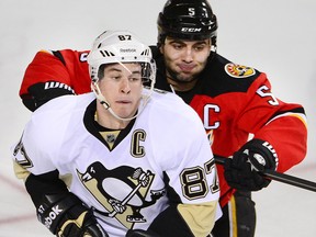 Flames defender Mark Giordano lowers the boom on Sidney Crosby during a game at the Scotiabank Saddledome in 2014.